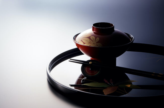 黒い漆のお盆の上に朱の漆器と塗り箸