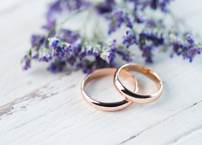 ラベンダーの脇に置かれたゴールド製の結婚指輪
