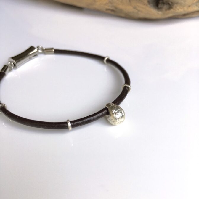 シルバーのワンポイントが入ったレザーコードブレスレット