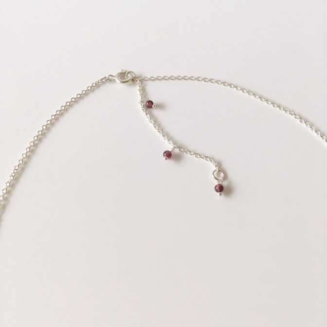 端にガーネットのビーズがついたシルバーチェーン
